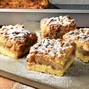 Side view of Polish apple cake slices on top of grey board.