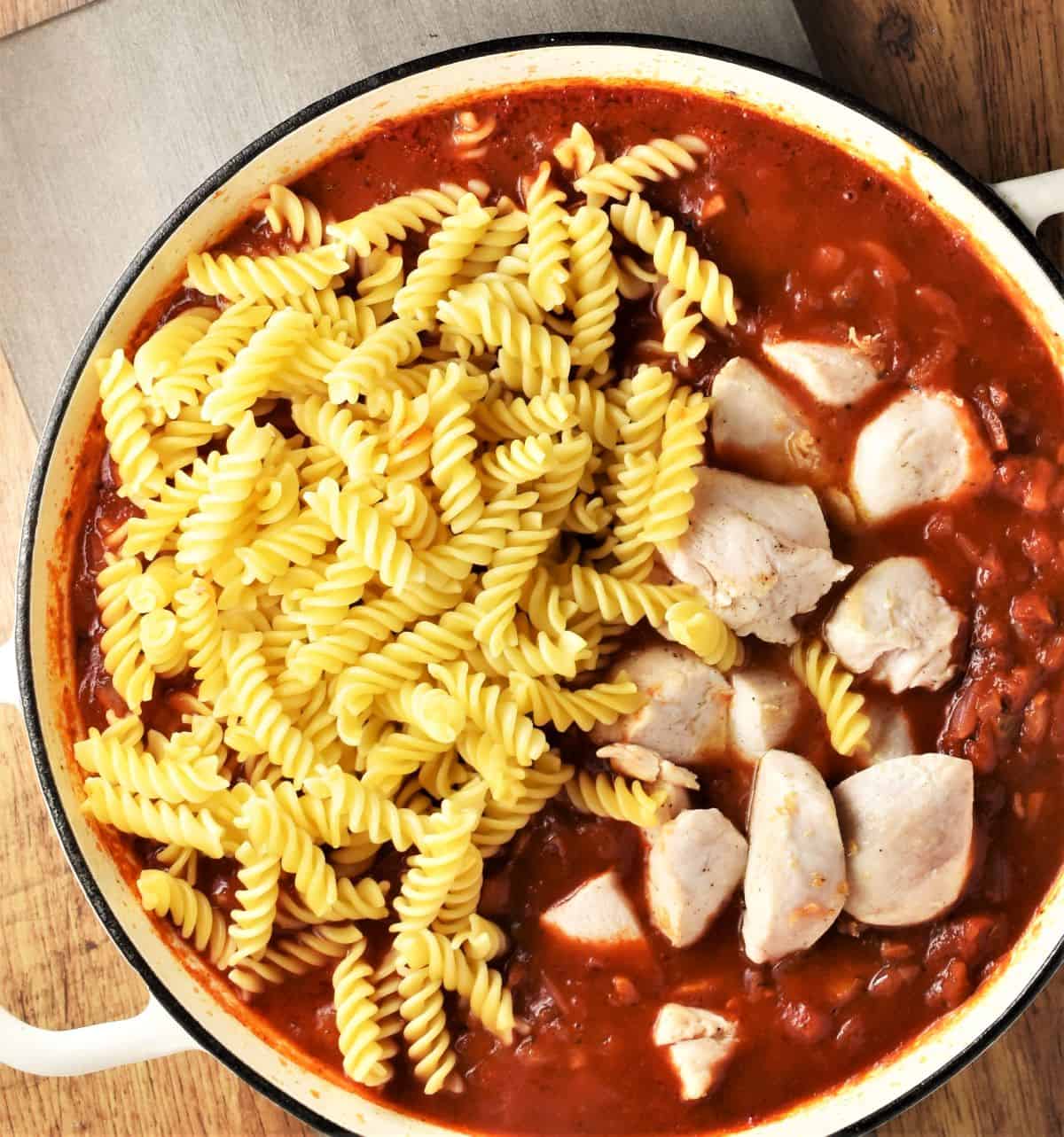 Fusilli pasta and chicken chunks in tomato sauce.