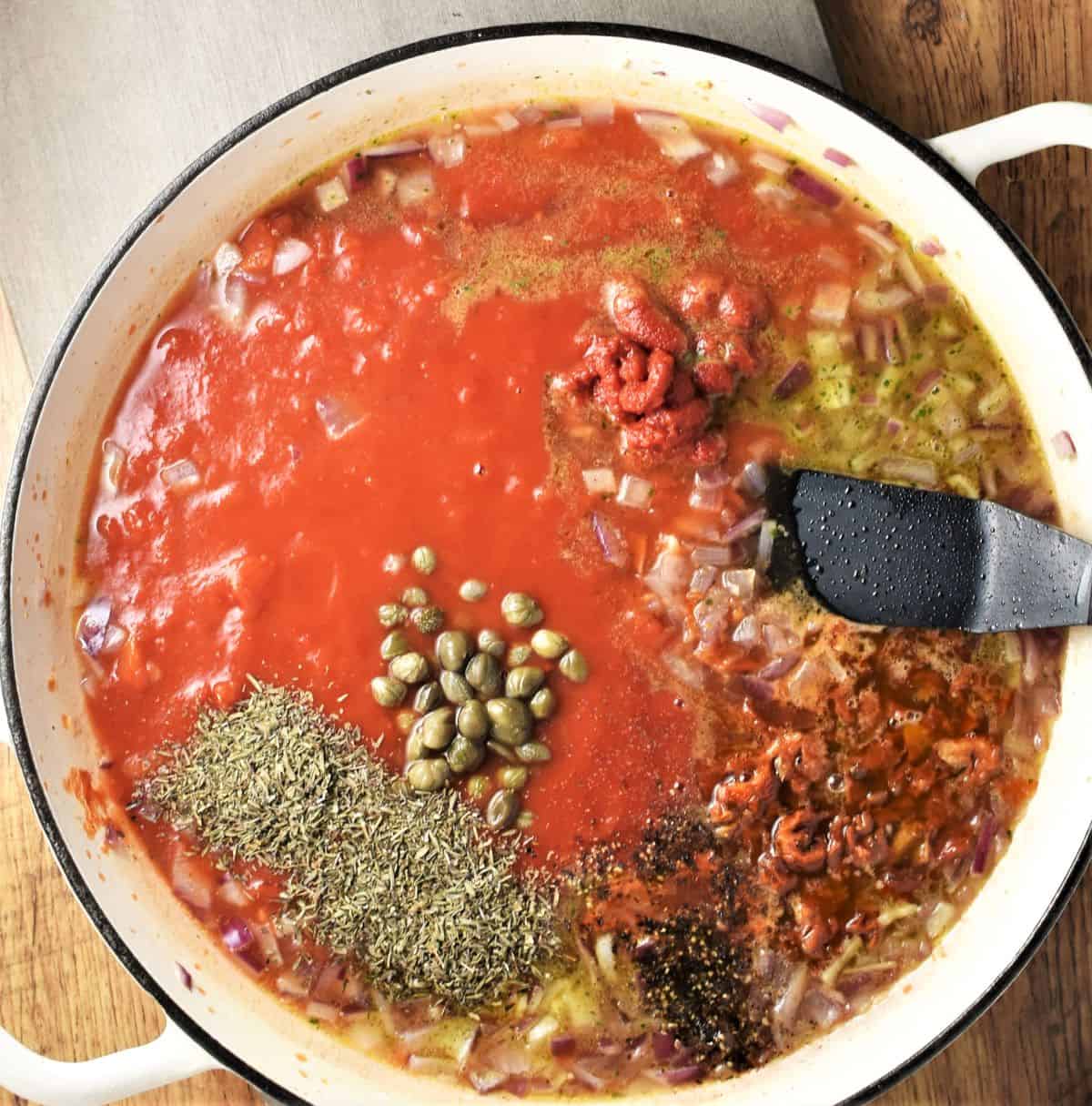 Making tomato sauce in large shallow dish for chicken pasta.