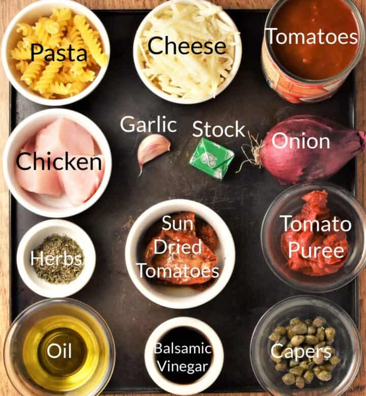 Ingredients for making tomato chicken pasta bake in individual dishes.
