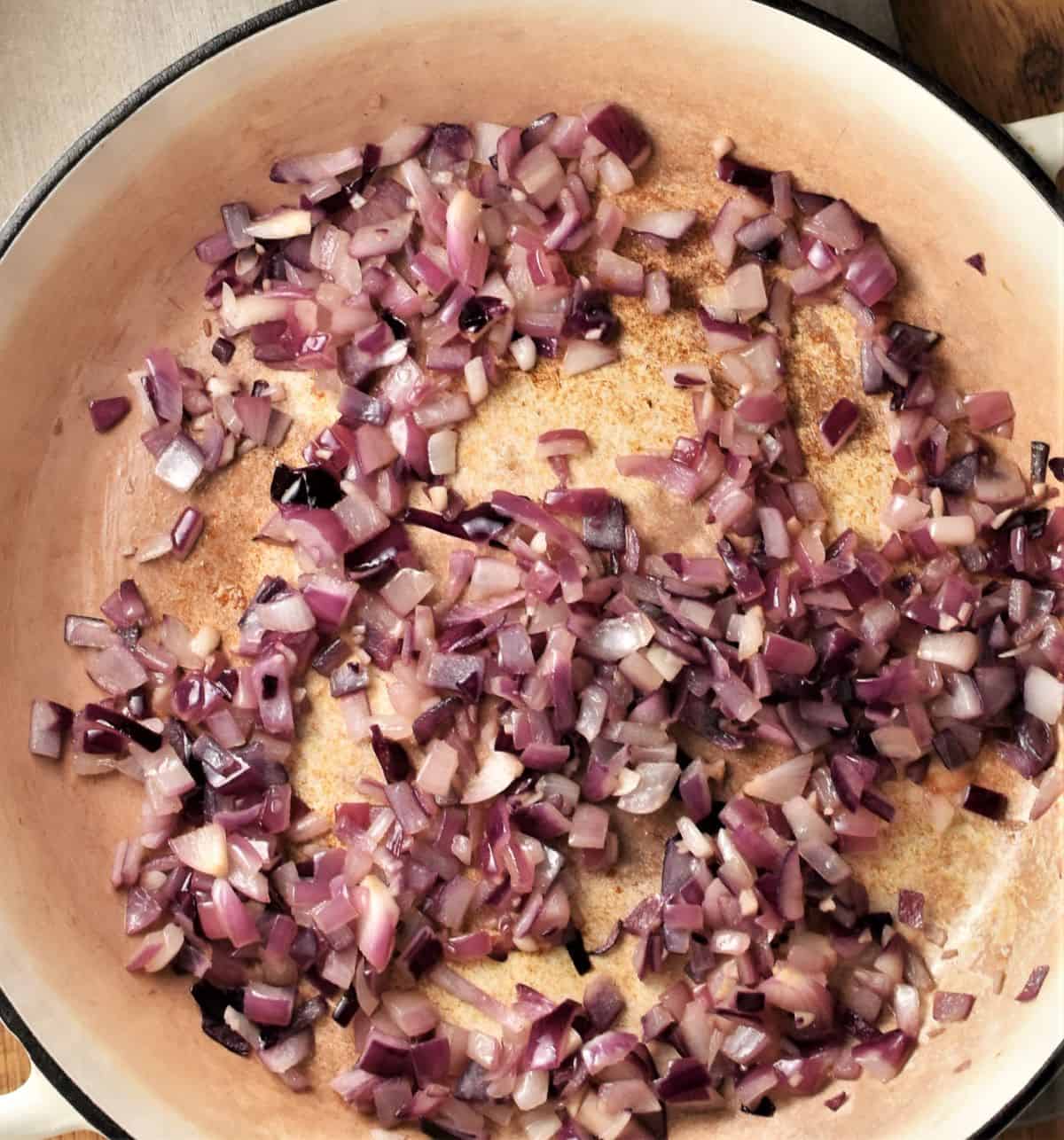 Frying chopped red onion in large shallow dish.