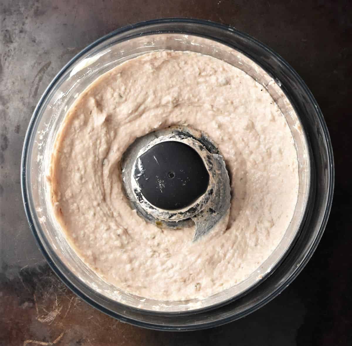 Creamy tuna spread in food processor bowl.