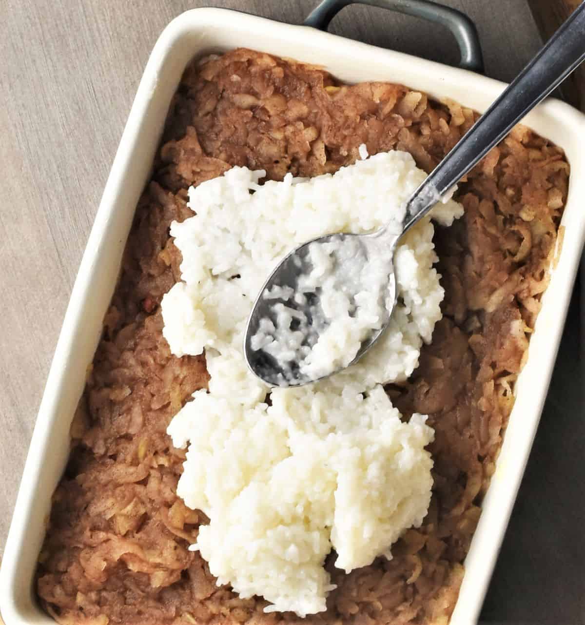 Assembling layers of rice and apple mixtures in rectangular dish.