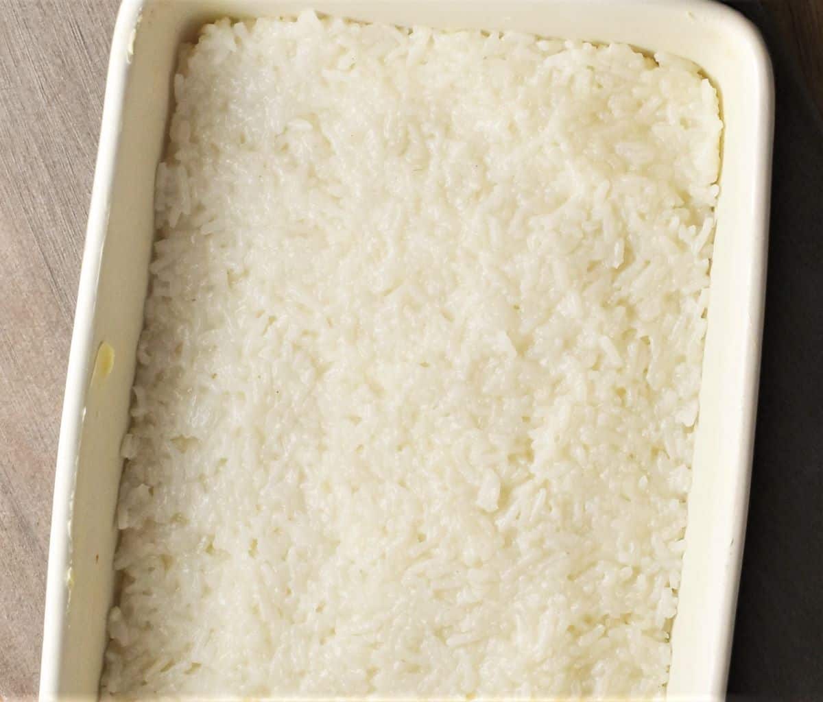 Layer of cooked rice in rectangular dish.
