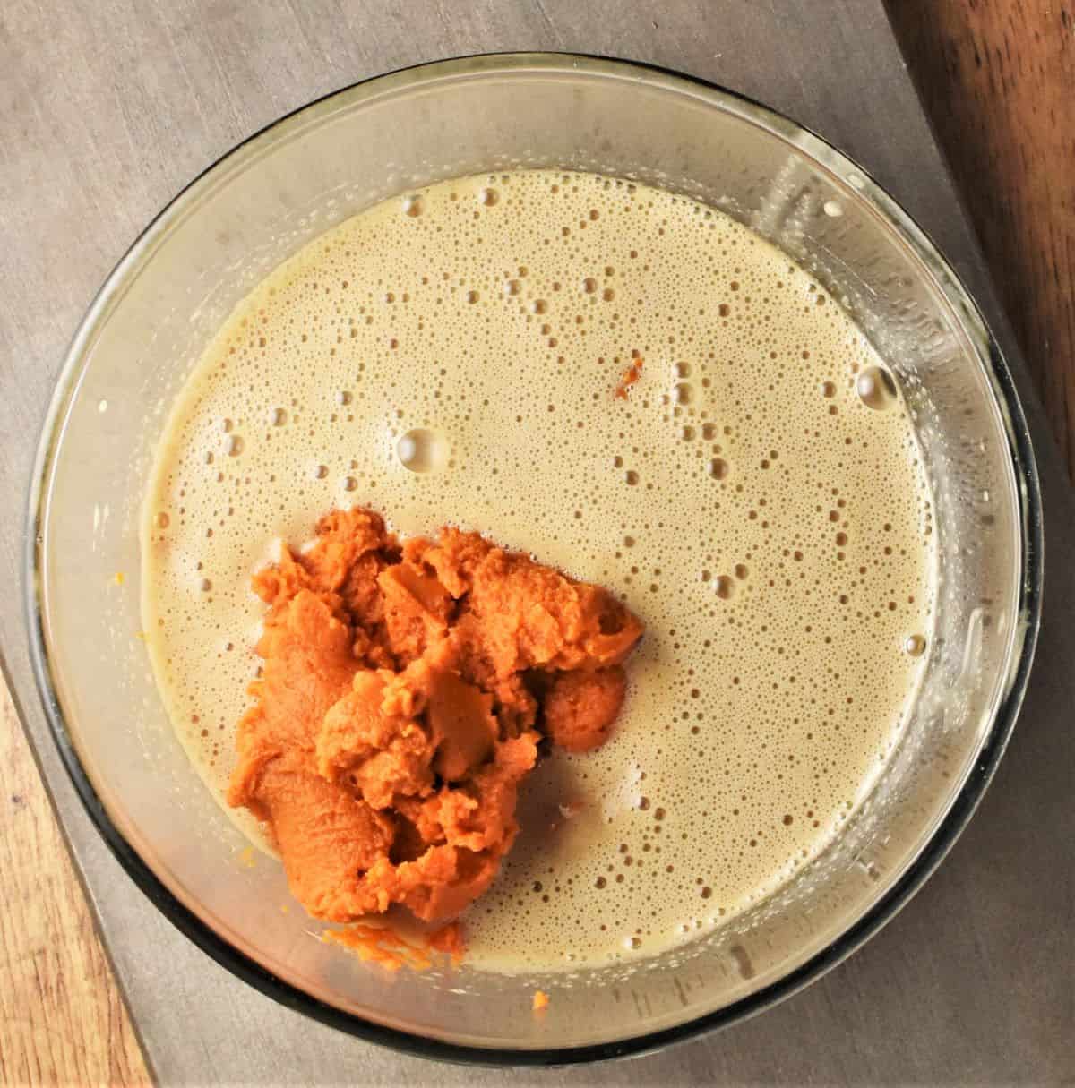 Wet ingredients mixture with pumpkin puree in bowl.