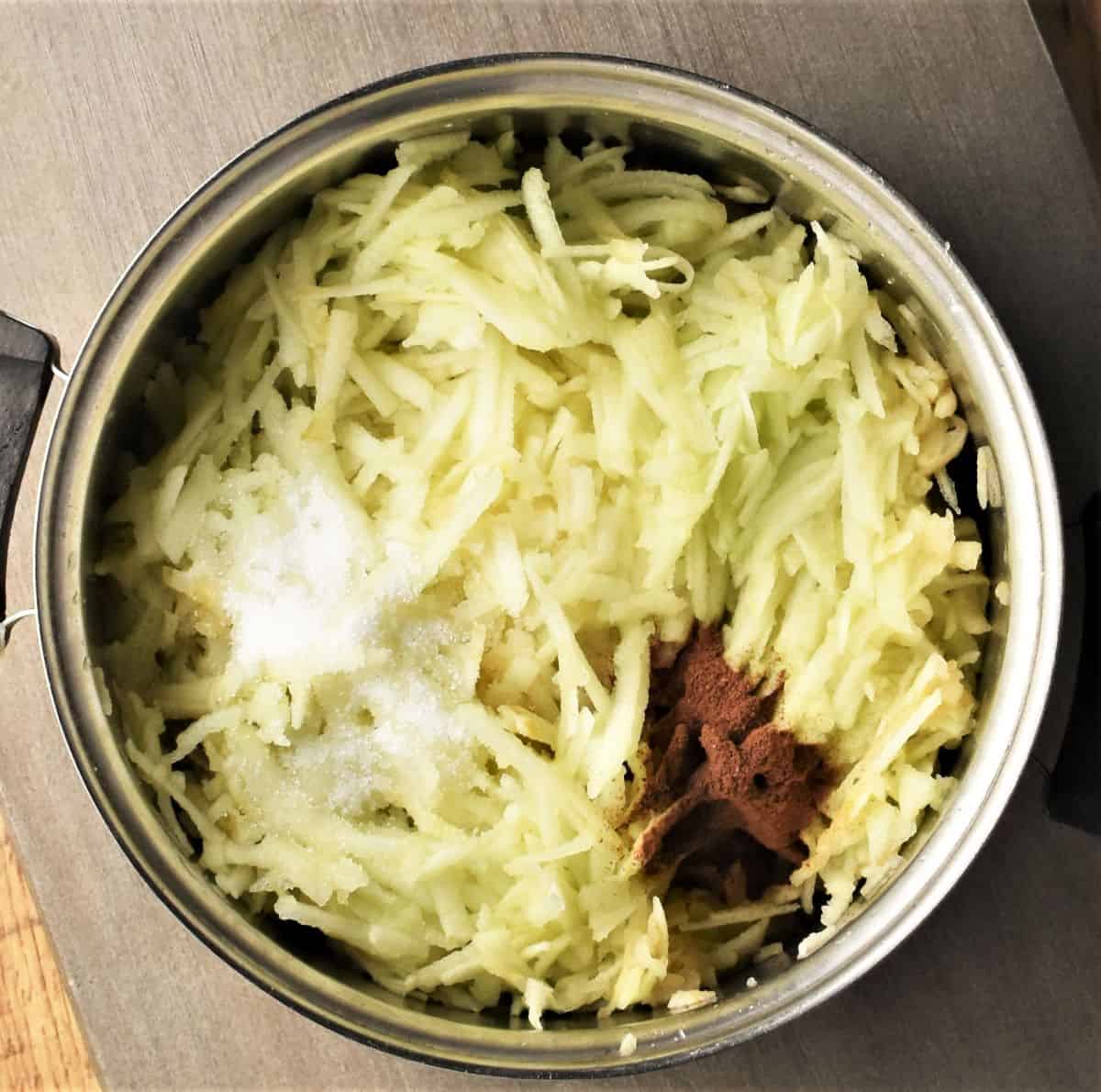 Stewing grated apples with spice and sugar in pot.