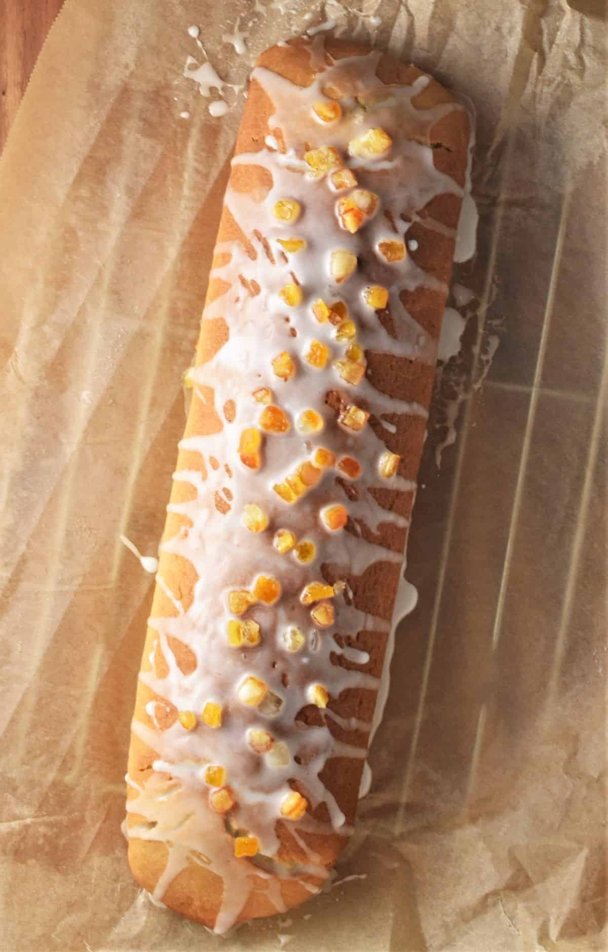 Polish poppy seed roll with glaze on top of parchment.