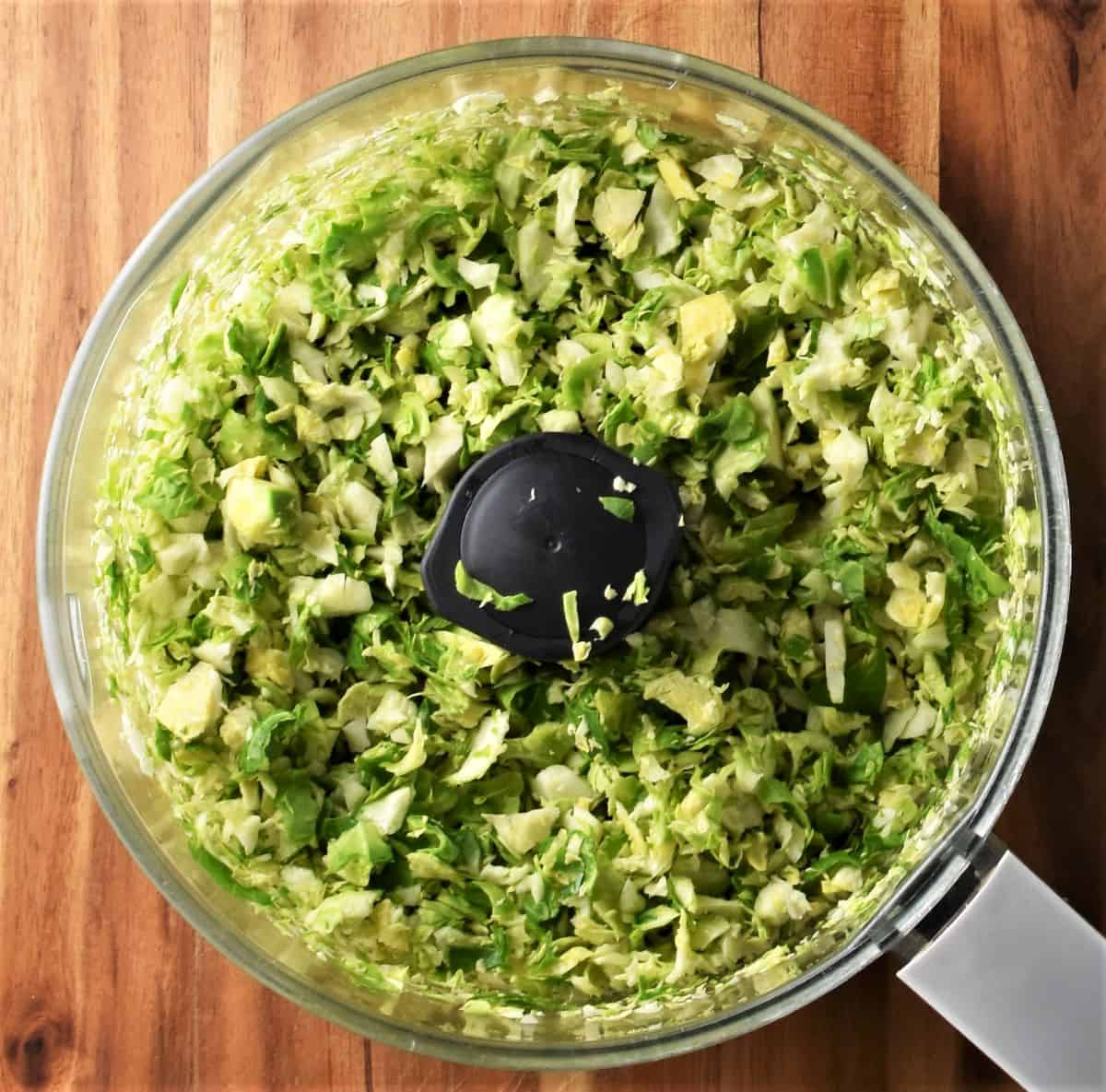 Shredded brussels sprouts in blender bowl.