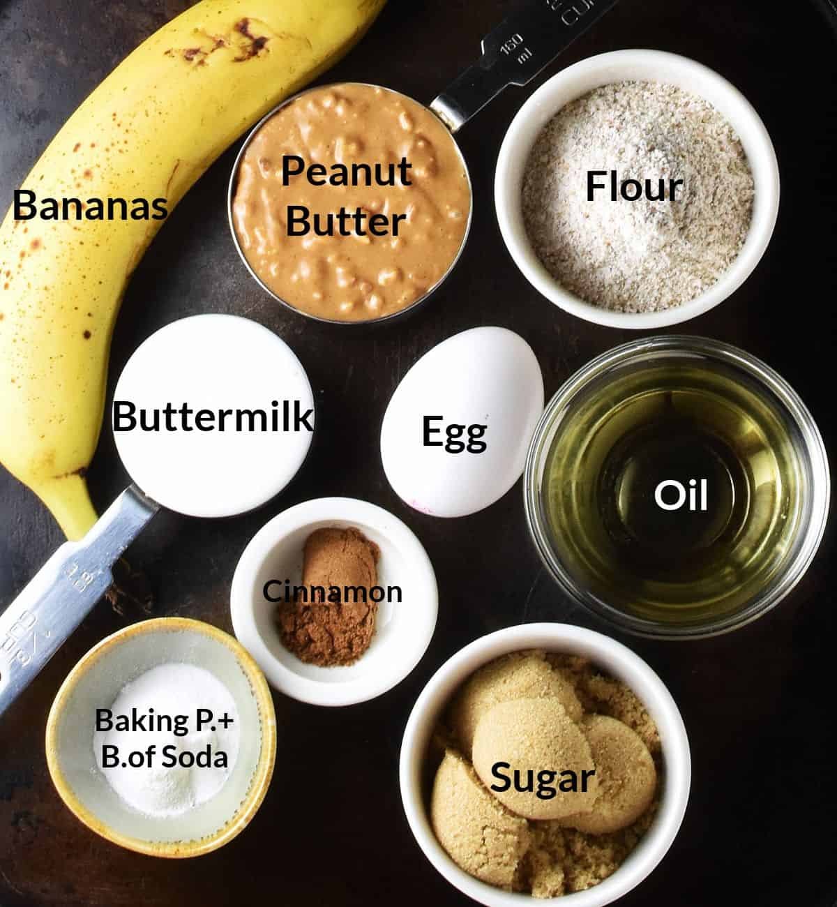 Top down view of ingredients for making banana and peanut butter muffins in individual dishes.