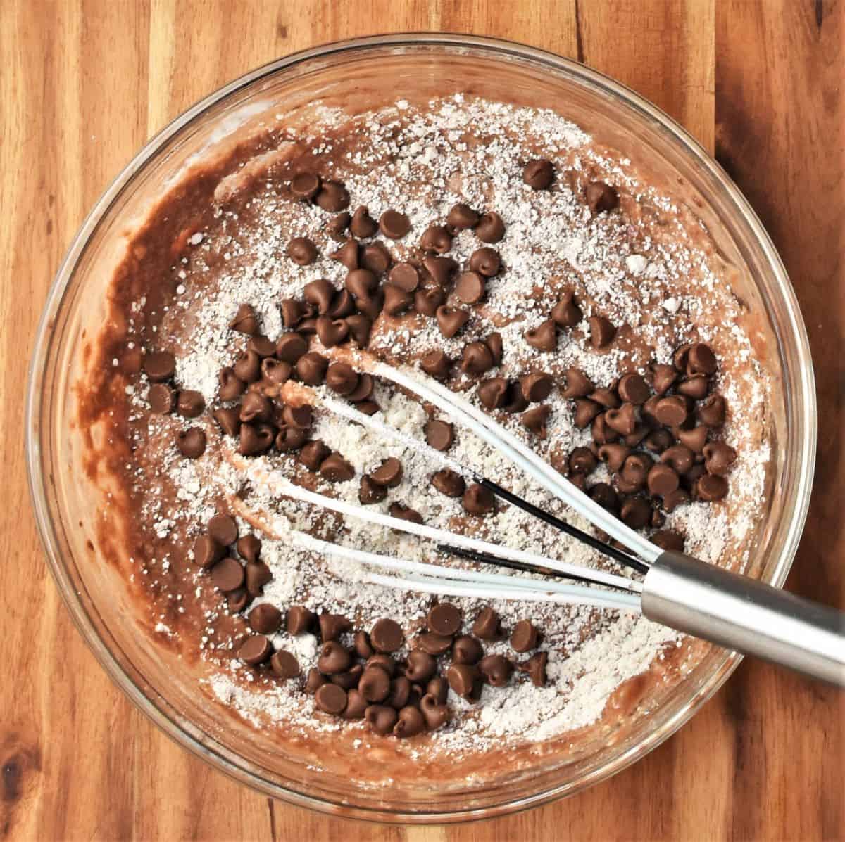 Adding chocolate chips to pancake batter.