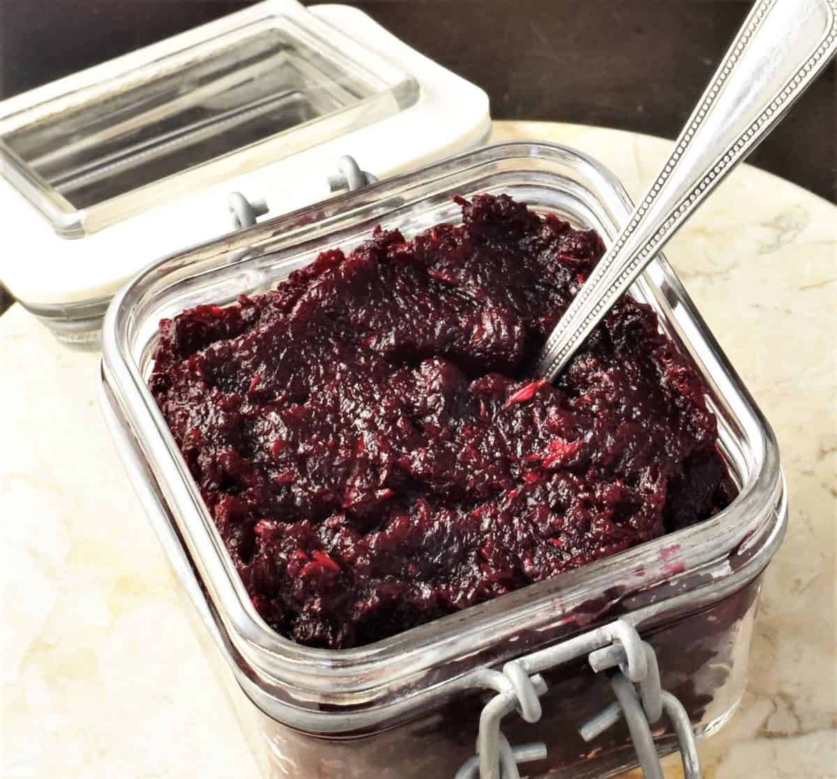 Side view of Polish beets with horseradish in open jar with spoon.