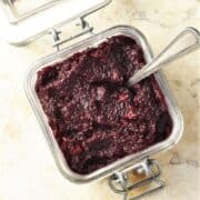 Top down view of Polish horseradish beets in open jar with spoon.