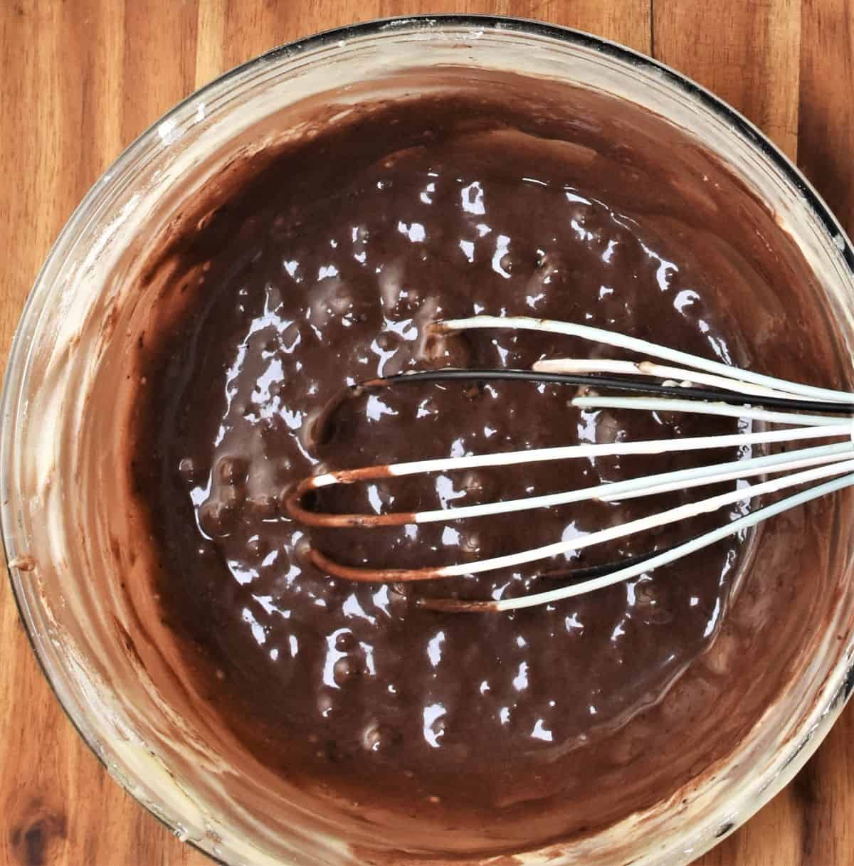 Cocoa mixture in bowl with whisk.