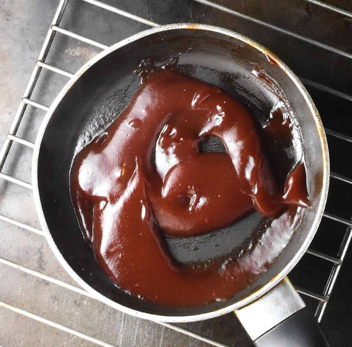 Glaze for meatloaf in small pan on top of rack.