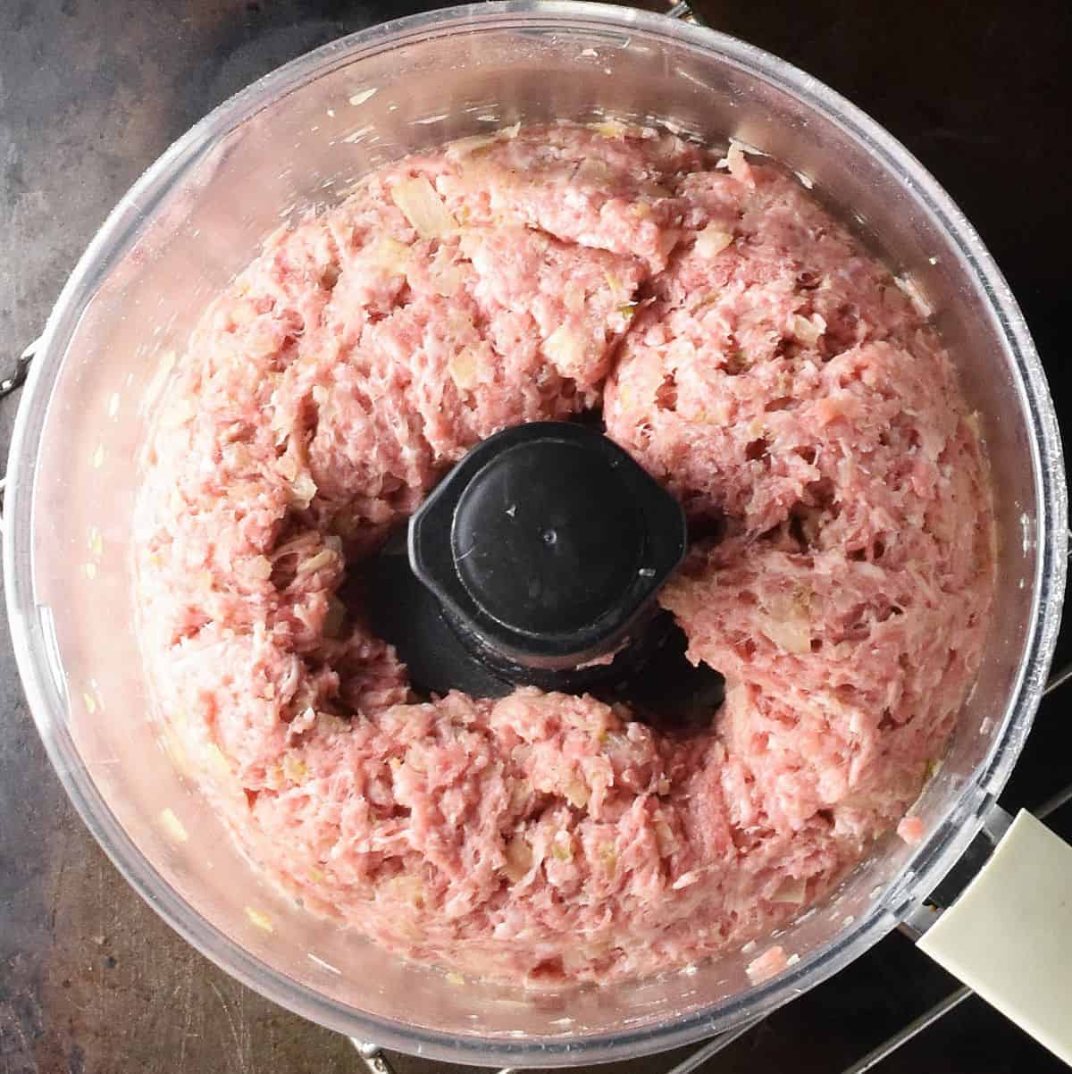 Ground meat mixture in food processor bowl.