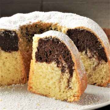 Side view of Polish babka slice and cake on white plate.