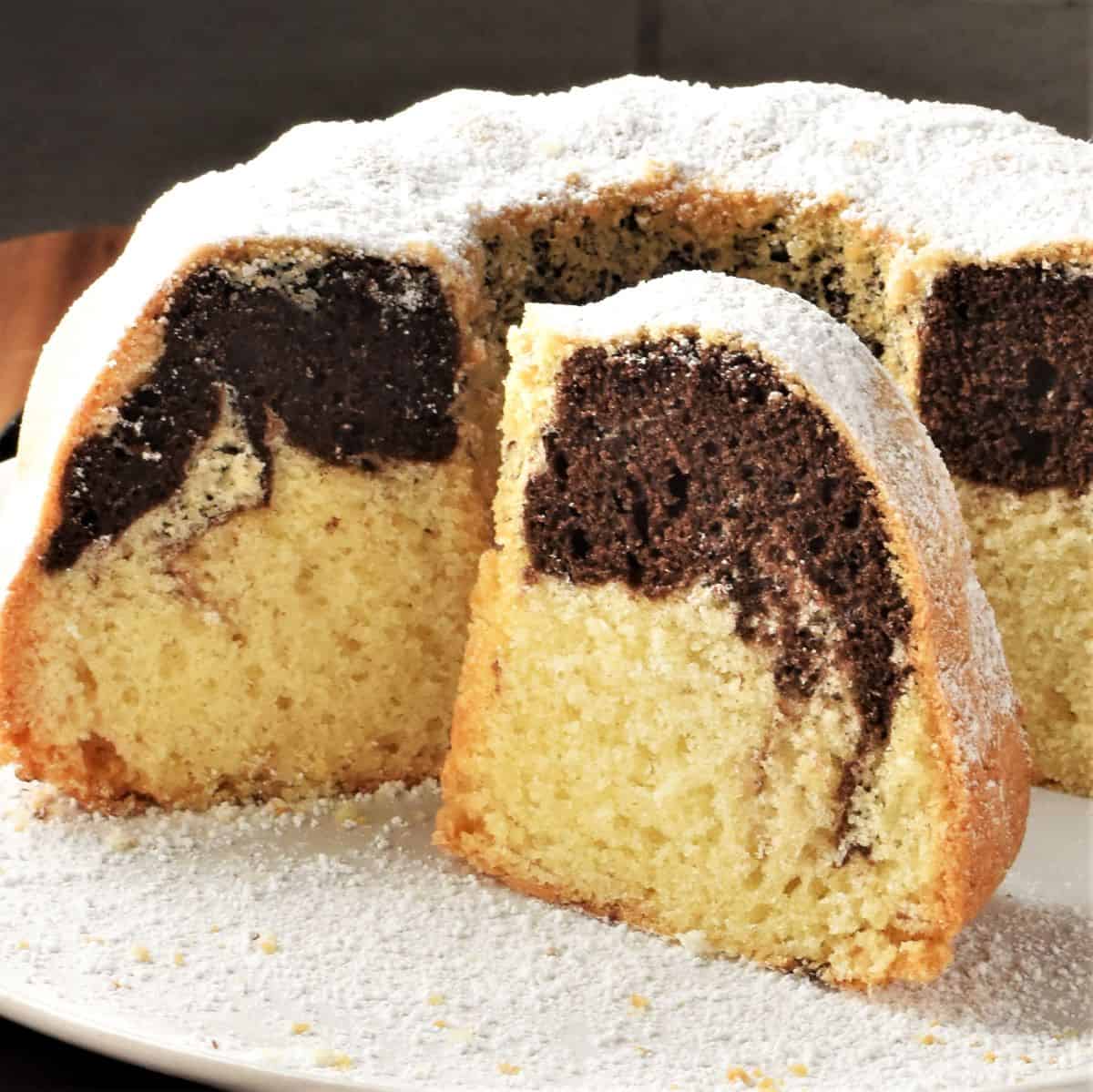 Side view of cut babka cake on white plate.