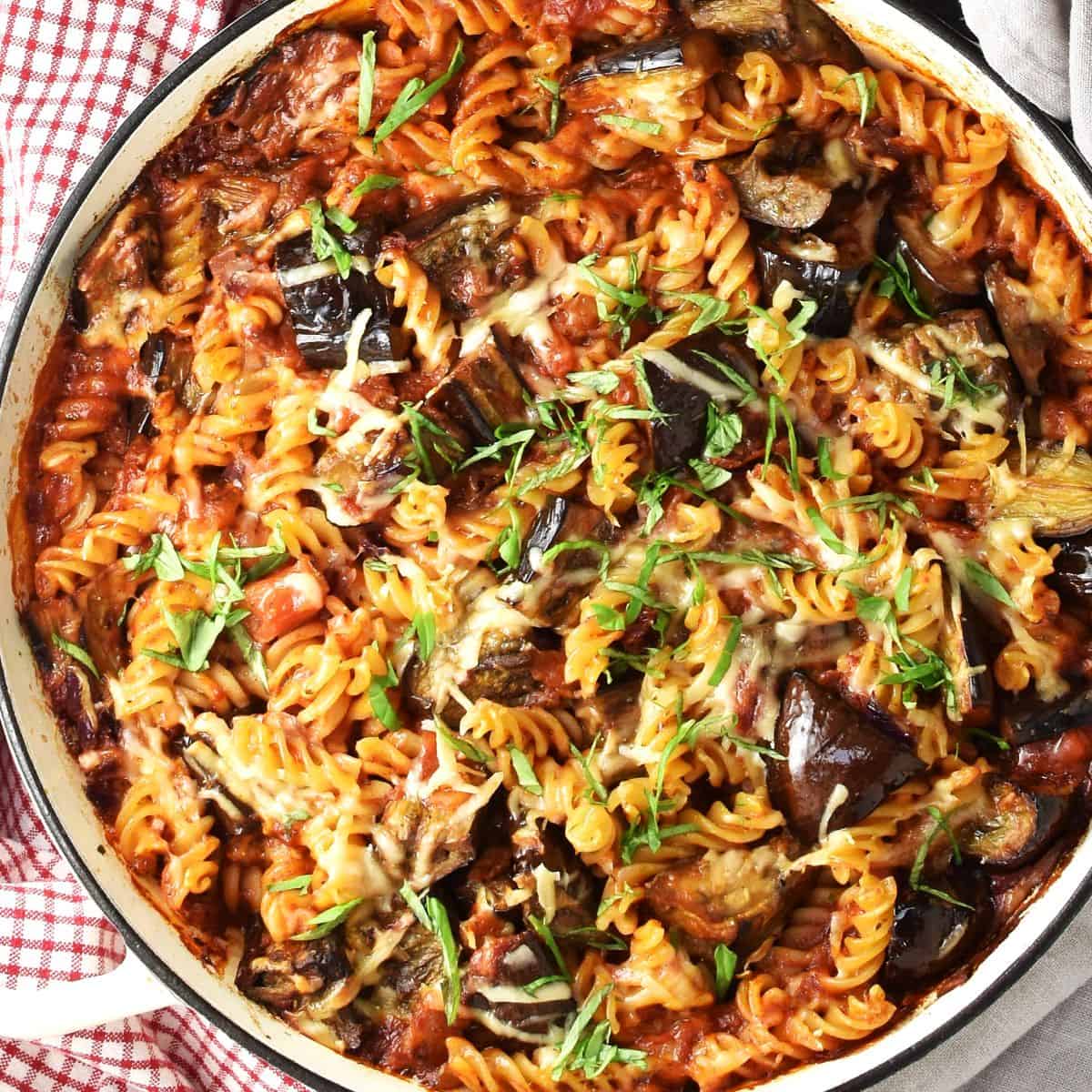 Top down view of eggplant pasta bake in shallow round pan.