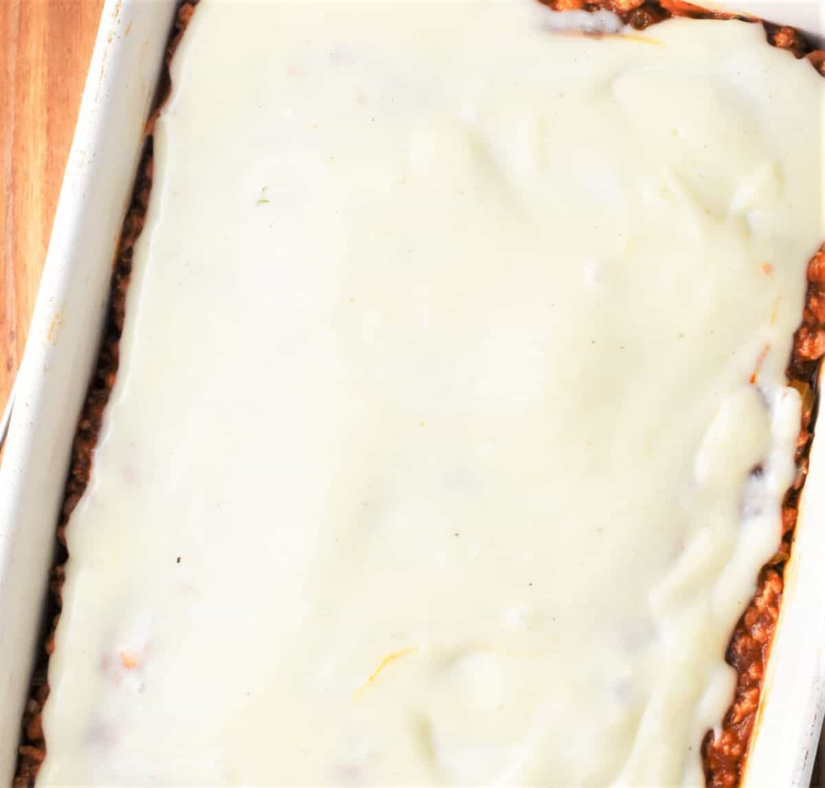 Lasagna layer with bechamel sauce on top.