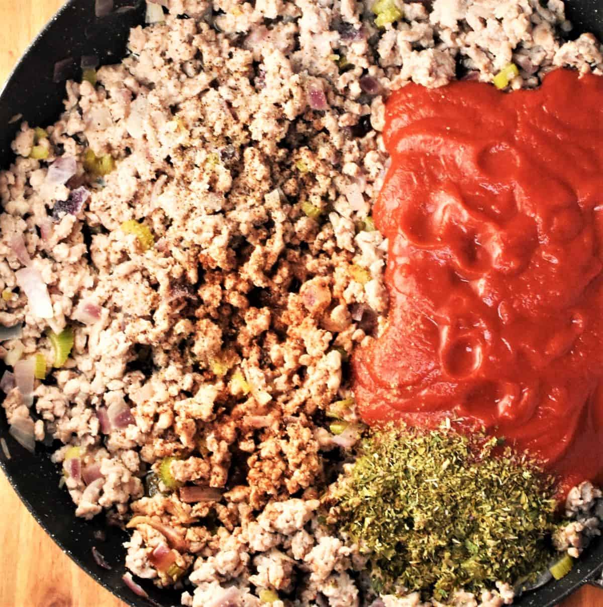 Making turkey and vegetable lasagna filling in large pan.