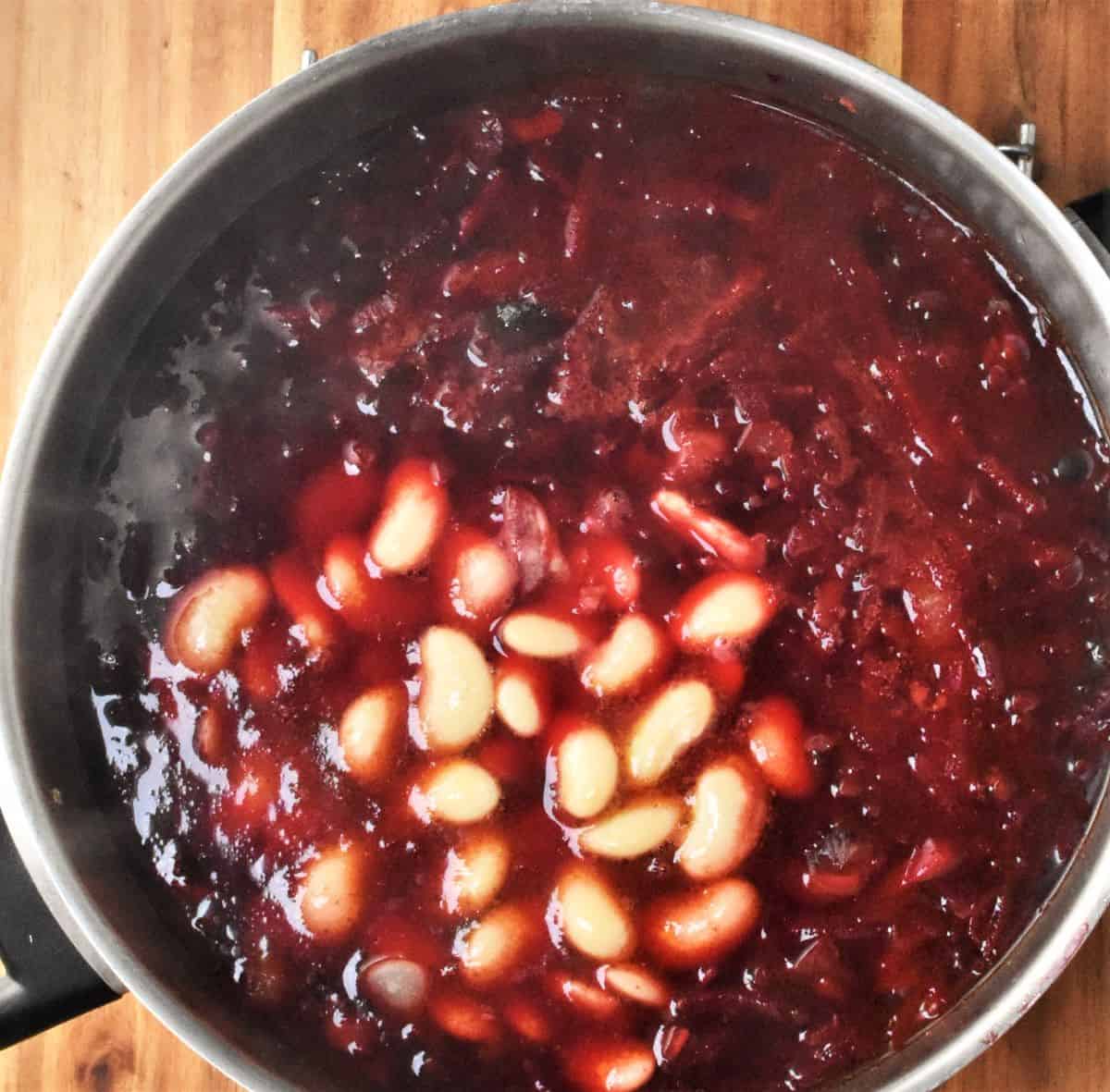 Ukrainian vegetarian borscht with beans in large pot.