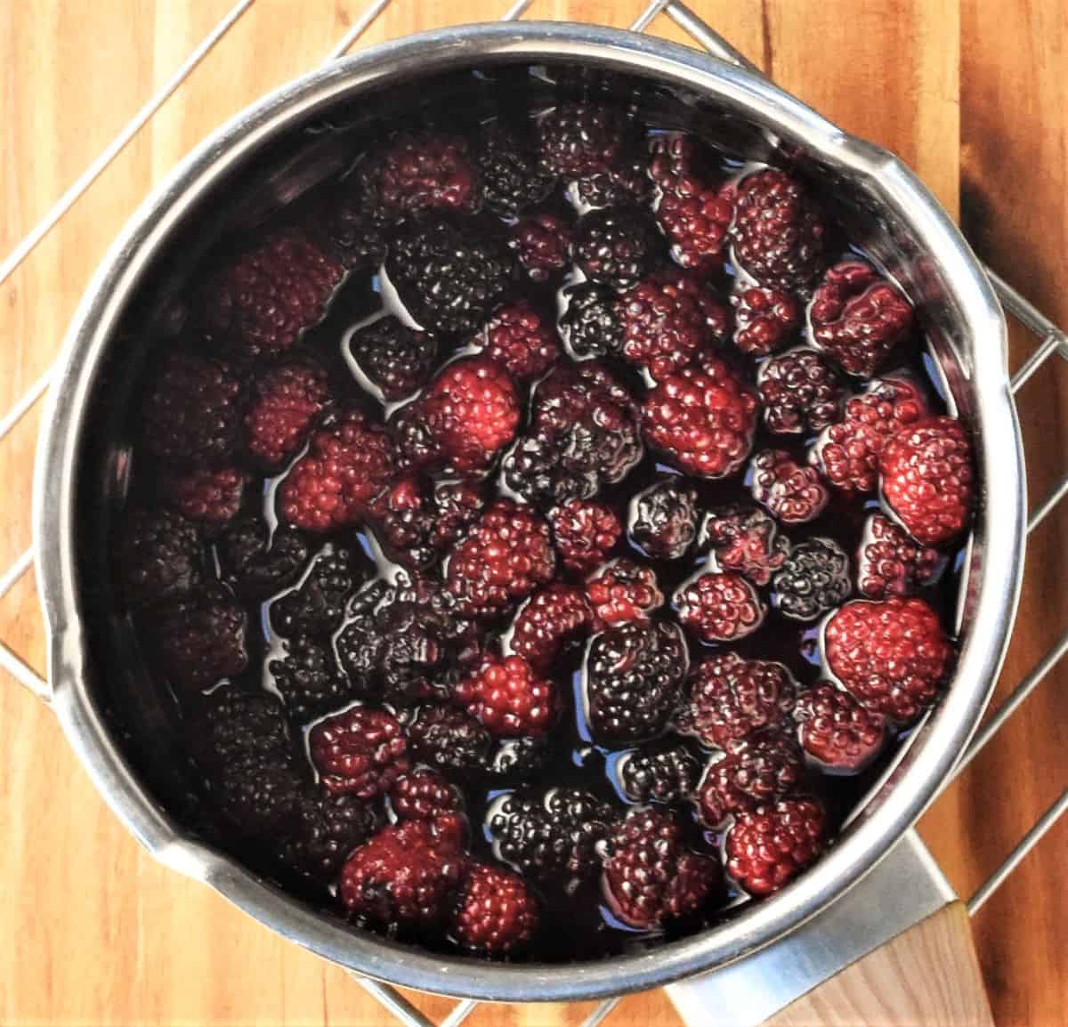 Cooking blackberry mixture in saucepan.
