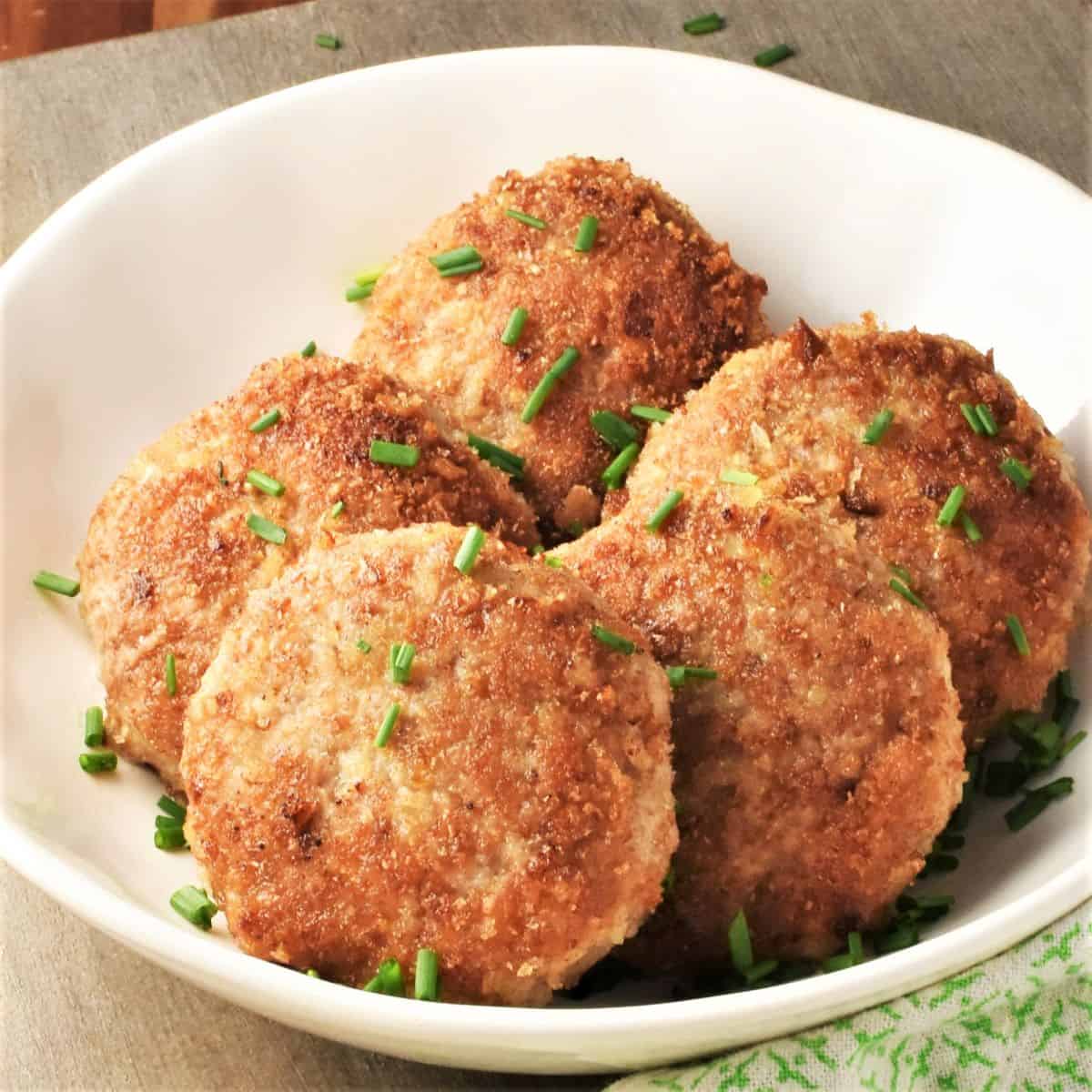 Side view of Polish kotlety in white bowl.