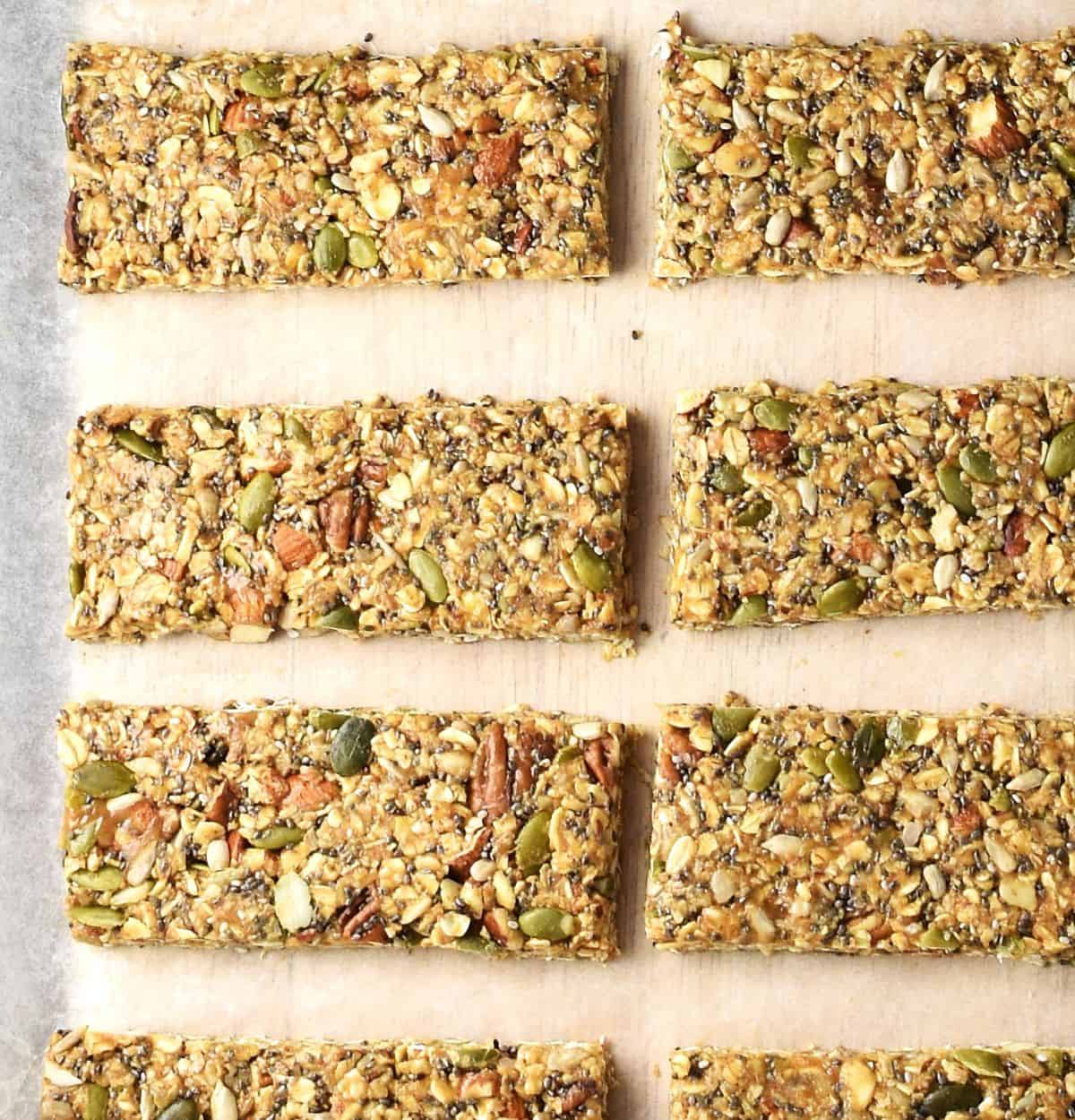 Top down view of unbaked homemade granola protein bars on parchment.