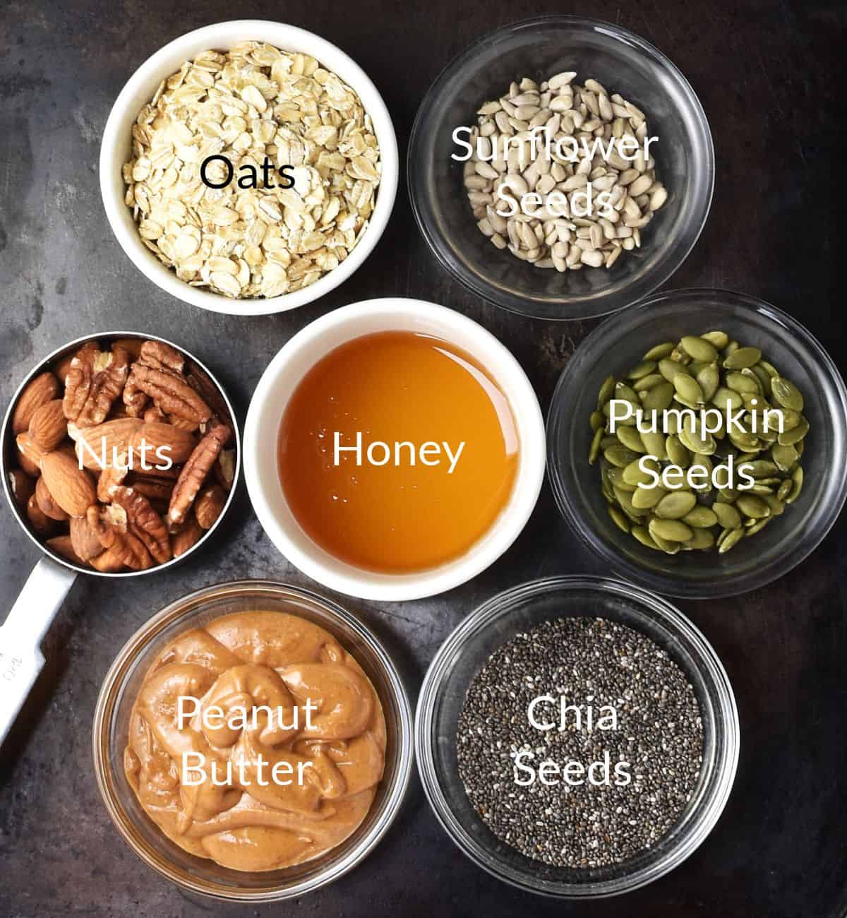 Top down view of ingredients for making homemade protein granola/muesli bars in individual dishes.