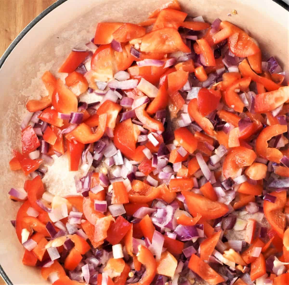 Sauteeing chopped vegetables in large shallow pan.