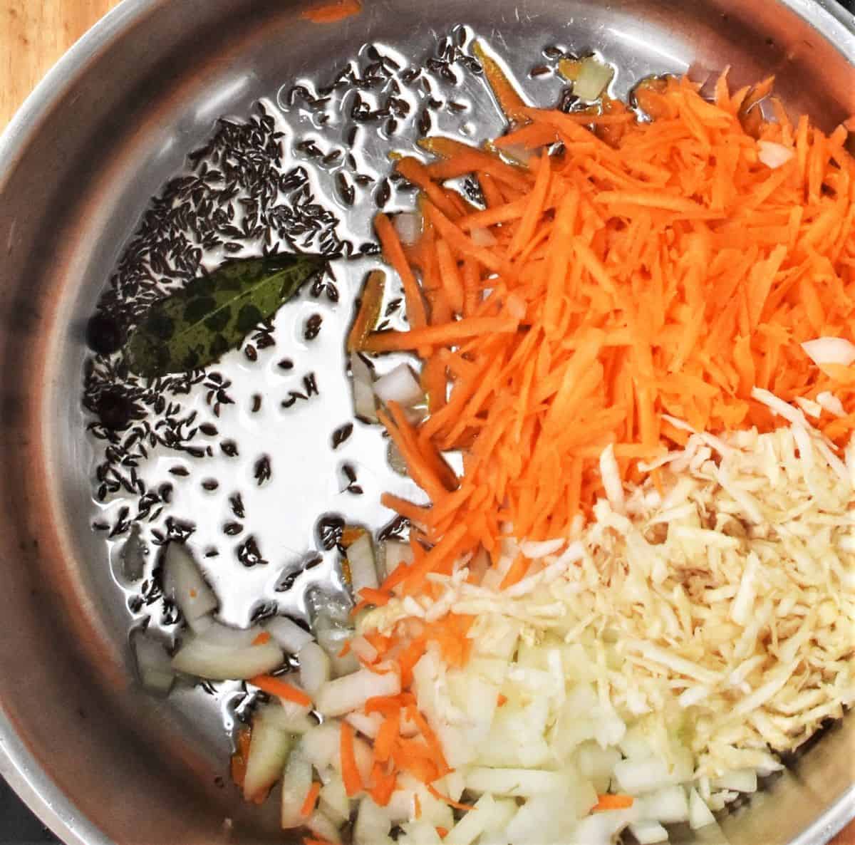 Making soup base with grated carrot, celery root and spices in large pot.