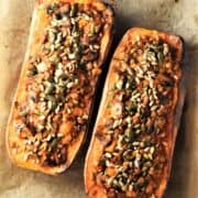 Top down view of 2 stuffed butternut squash halves on parchment.