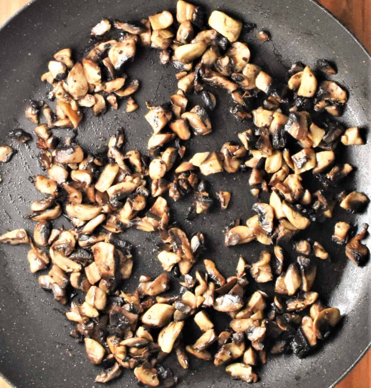Chopped mushrooms in large shallow pan.