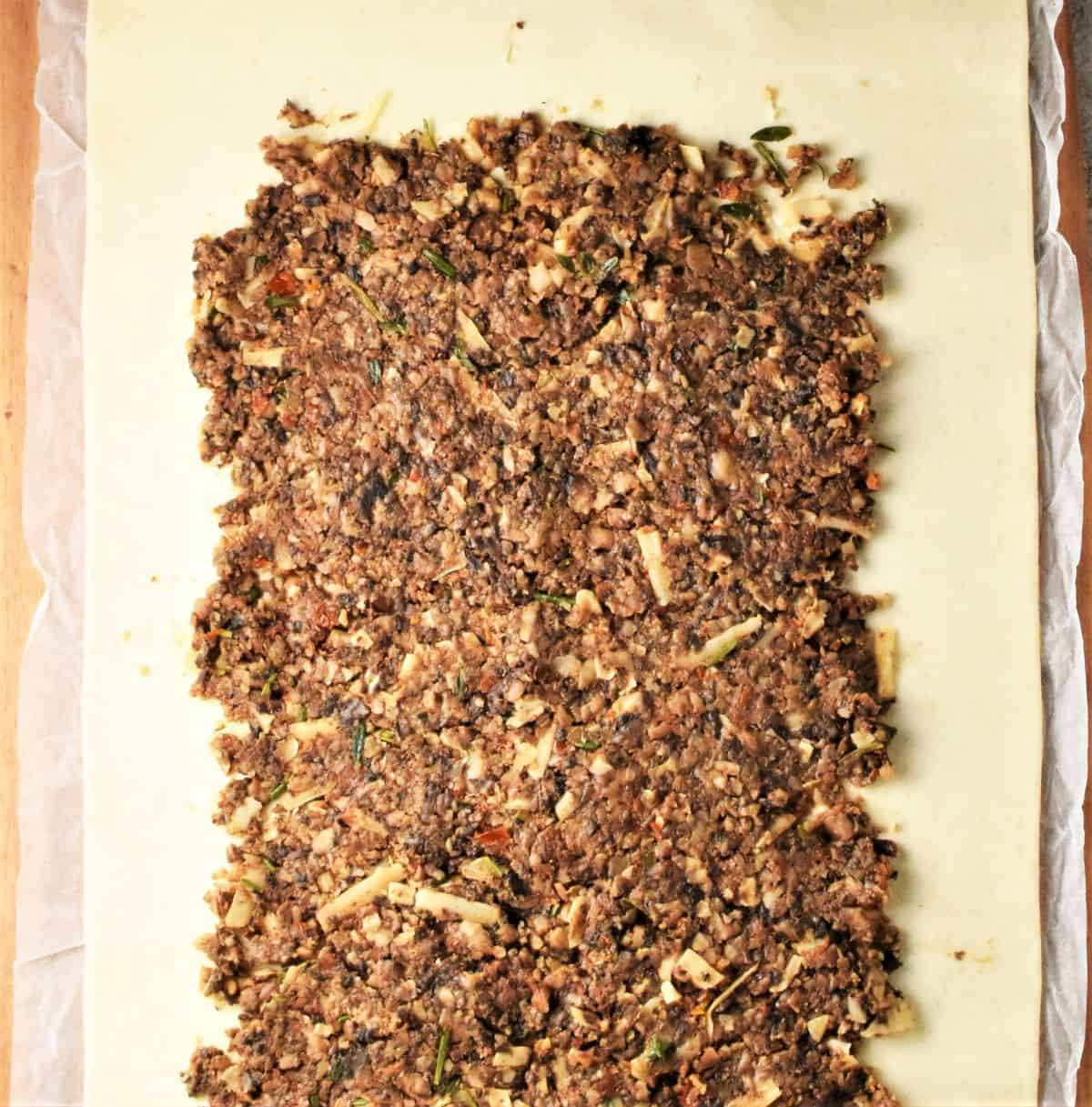Mushroom mixture spread over pastry sheet.