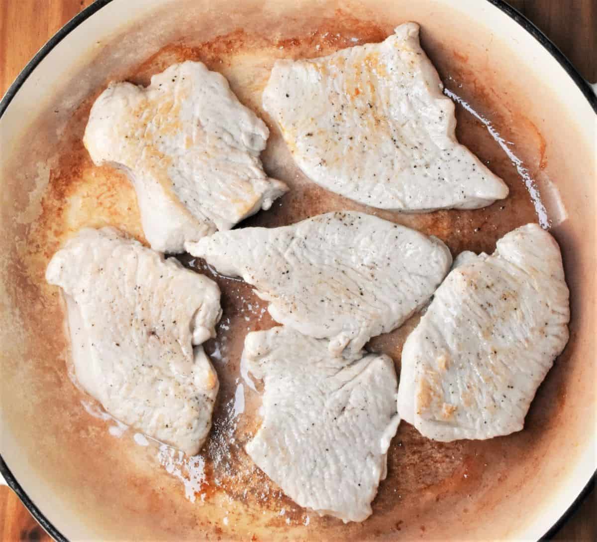 Searing turkey breast cutlets in large shallow pan.