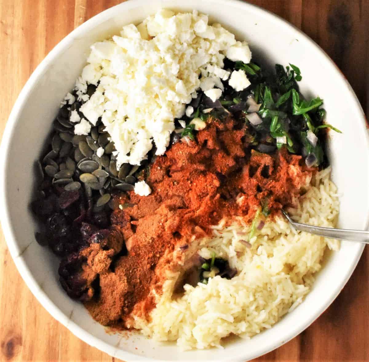 Ingredients for stuffing pumpkin in white bowl with spoon.