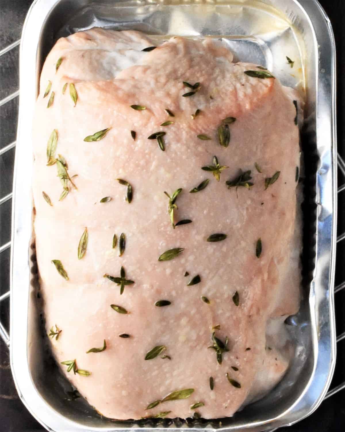 Cooked turkey breast in tin container.