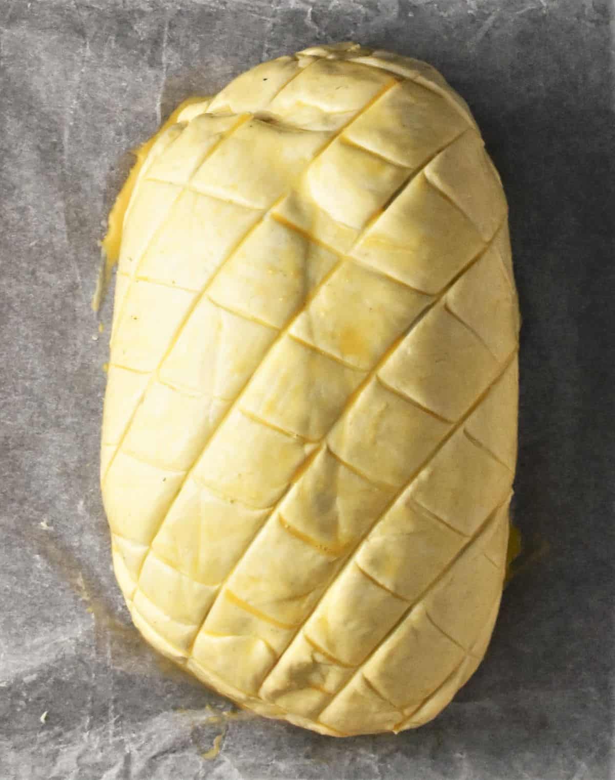 Turkey wellington in puff pastry on top of parchment.