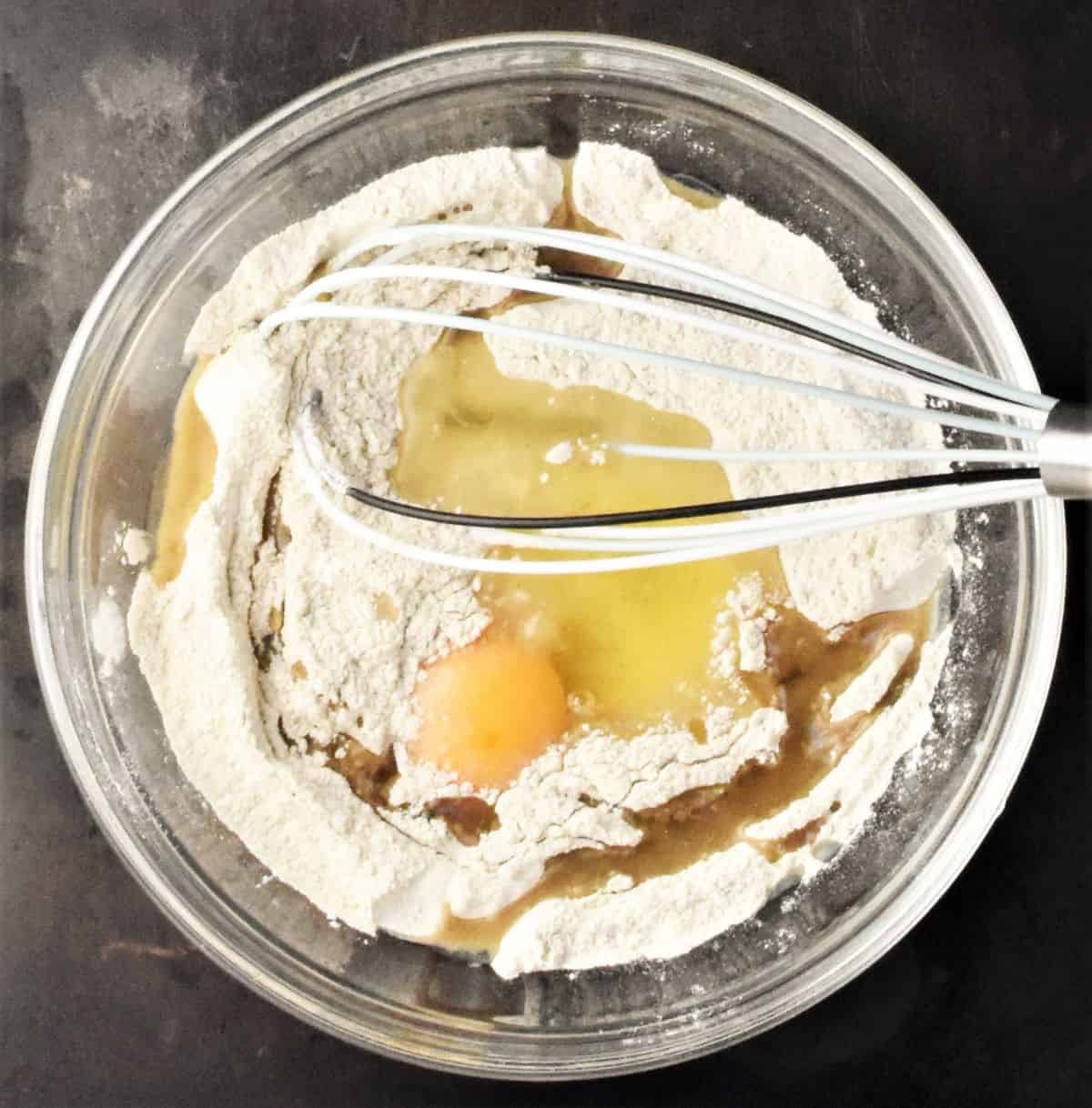 Buckwheat flour with milk in mixing bowl with whisk.