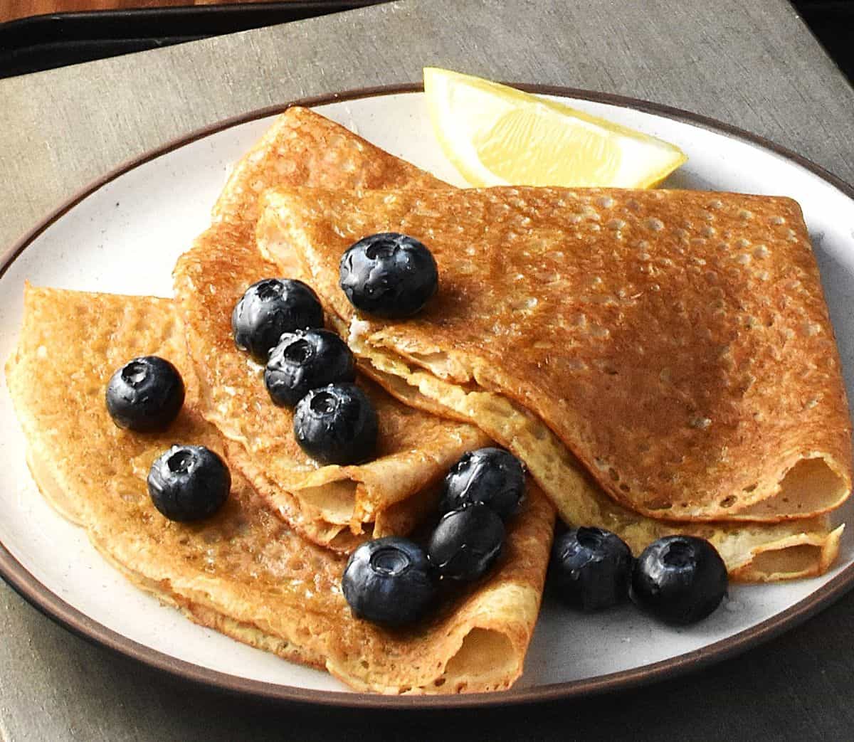 Side view of folded buckwheat flour crepes with blueberries.