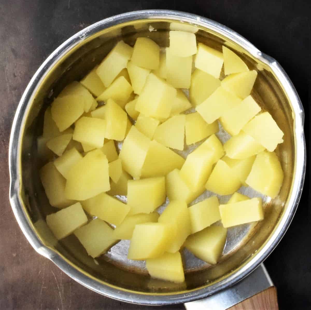 Peeled, cubed potatoes in pot of water.