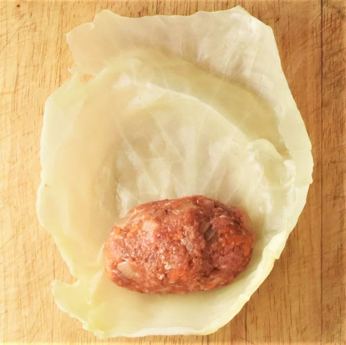 Top down view of cabbage leaf with meat filling ball.
