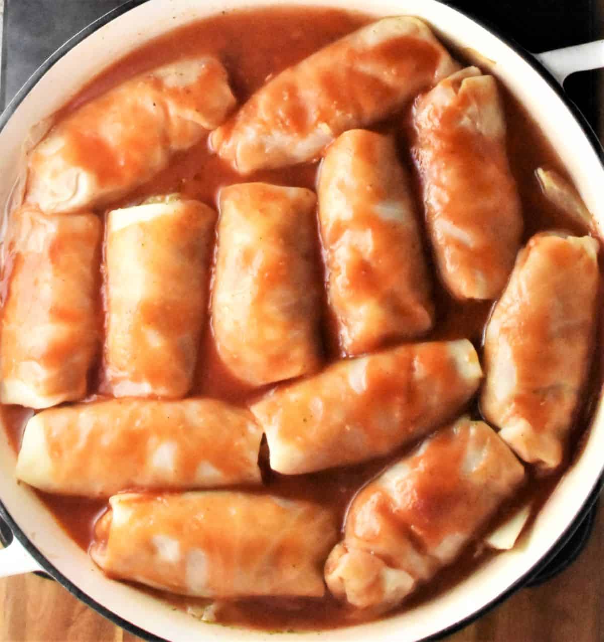 Top down view of cabbage rolls with tomato sauce in casserole dish.
