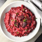 Top down view of beet risotto in grey bowl.