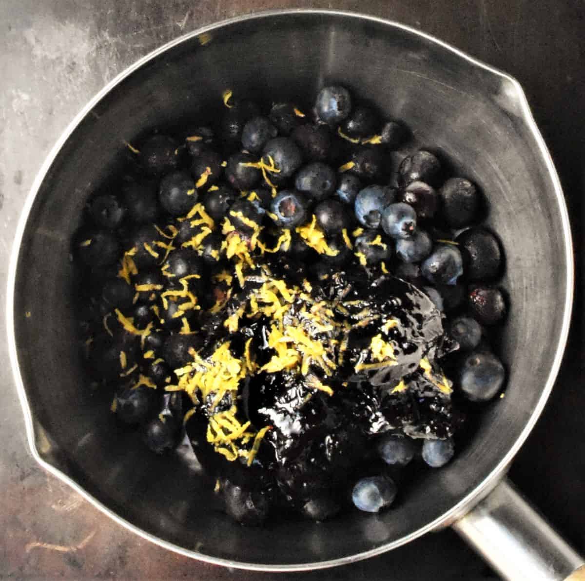 Blueberries and lemon zest in pan.