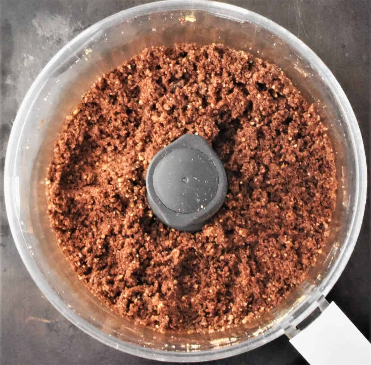 Top down view of chocolate crumble mixture in food processor.