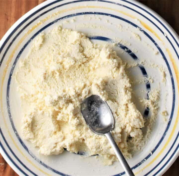 Creamy cheese mixture in bowl with spoon.