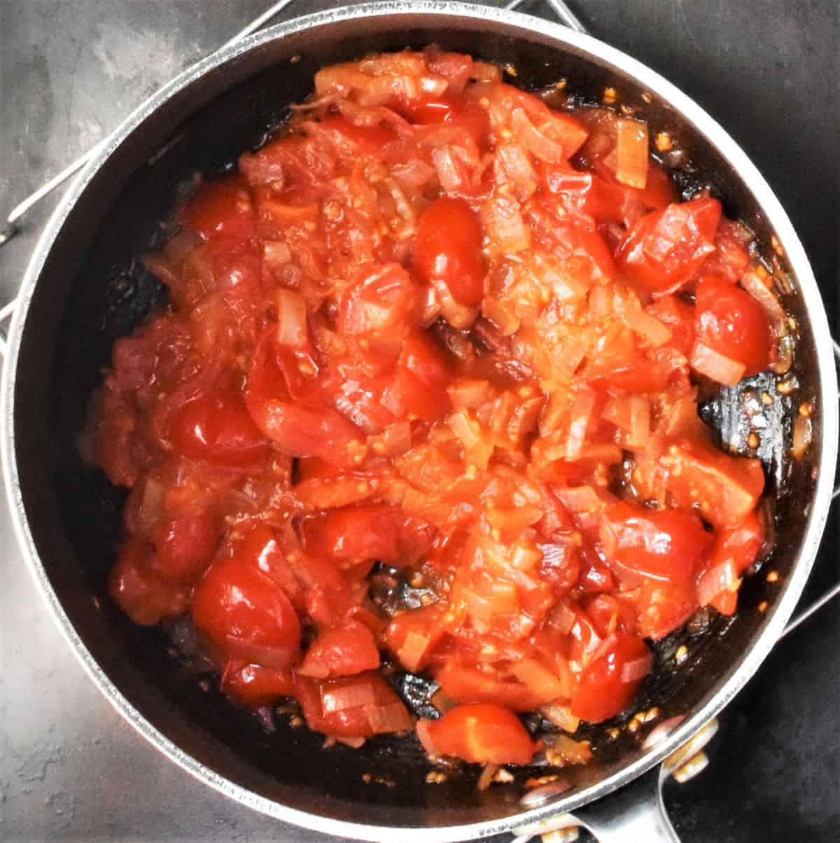 Tomatoes and shallots in large pot.
