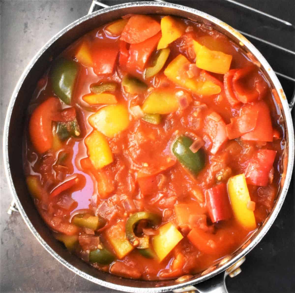 Top down view of tomato and pepper stew in pot.