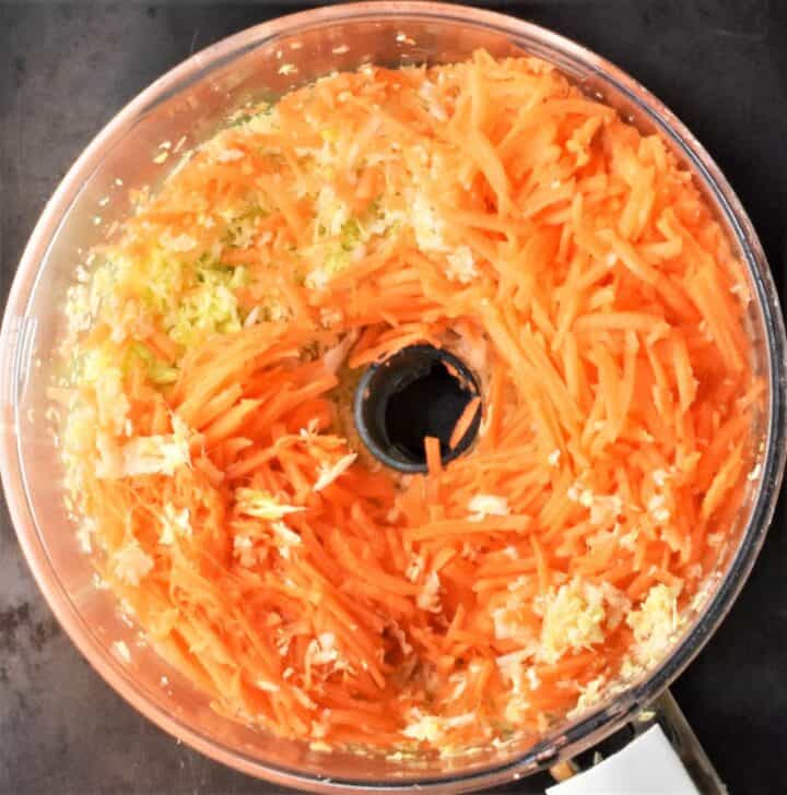 Shredded carrot in food processor bowl.